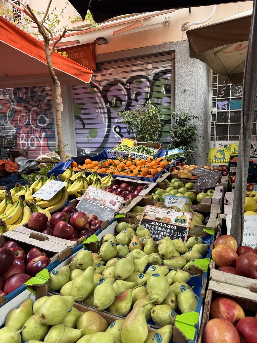 Fruit market stall with graffiti-covered shutters behind it