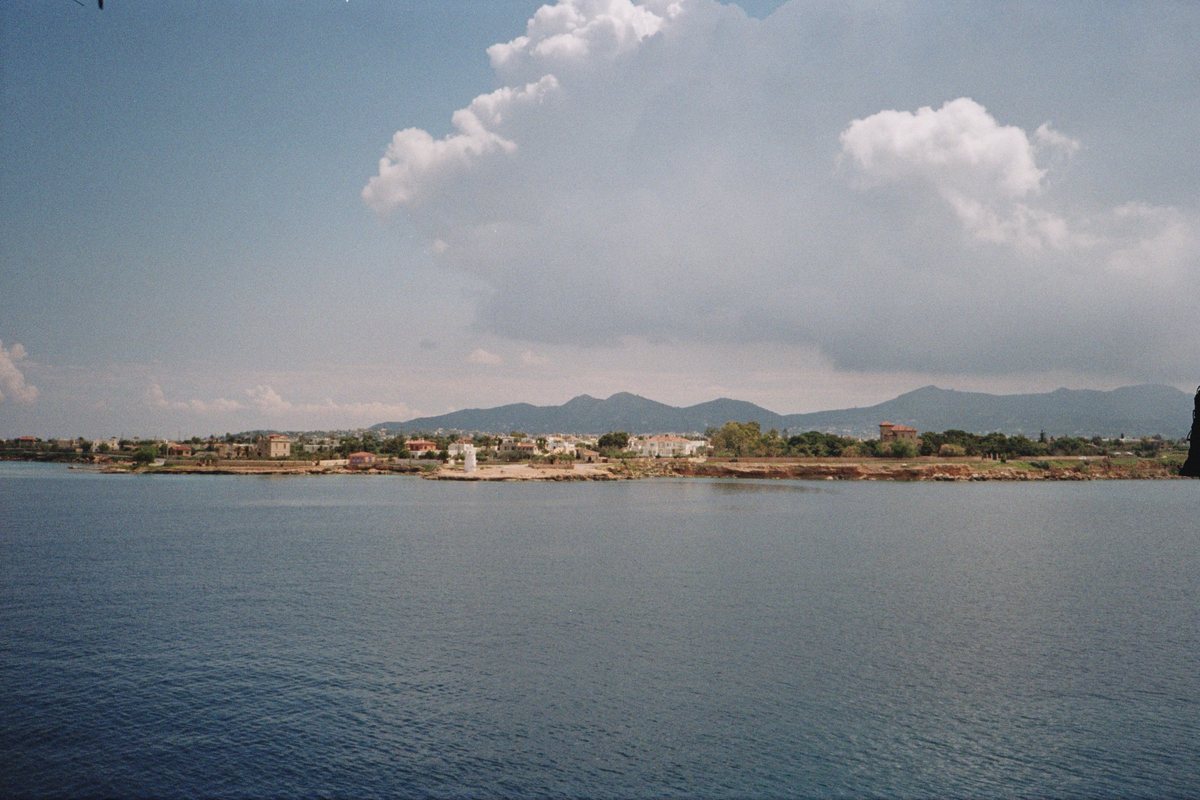 A coastal village beneath a large cloud formation